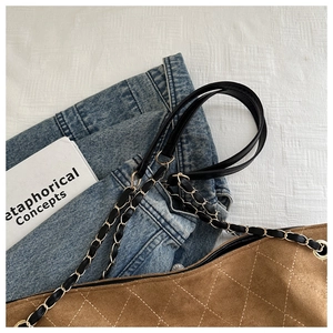 Close-up of quilted suede texture and woven gold chain strap on brown tote bag