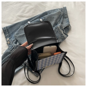 Détail de l'intérieur du sac à dos à carreaux bleus montrant le rangement du téléphone