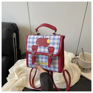 Détail du mini sac à dos à carreaux avec broderie pomme et fermeture à boucles