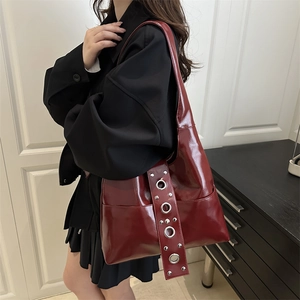 Retro punk style dark red glossy leather shoulder bag with metallic rivets and studs