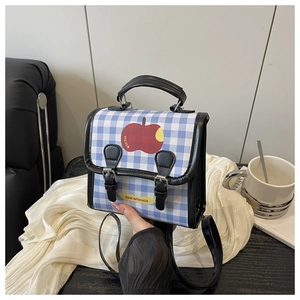 Détail du mini sac à dos à carreaux bleus avec motif pomme et lanières en cuir noir