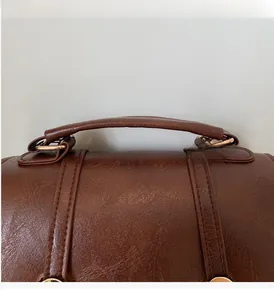 Close-up of durable top handle on a dark brown vintage faux leather backpack