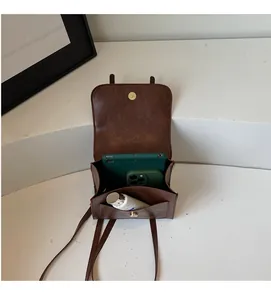 Interior view of brown vintage backpack showing capacity for smartphones and cosmetics