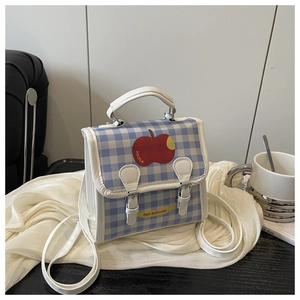 Détail du sac à dos à carreaux bleus avec motif pomme rouge et slogan Not anxious