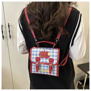 Vue détaillée du mini sac à dos à carreaux avec motif pomme et bretelles réglables