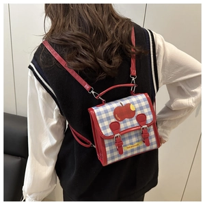 Sac à dos à carreaux rouges et bleus avec motif pomme porté par un mannequin