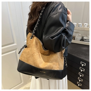 Detail of vintage quilted tote bag with brown suede texture and metal chain strap