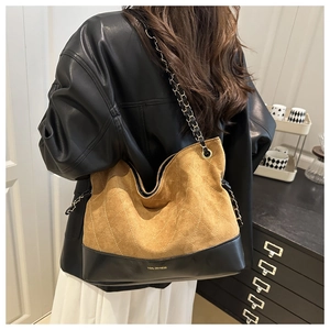 Detail of vintage quilted tote bag showing brown suede and black leather contrast textures