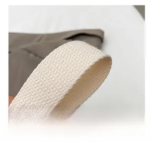 Macro shot of comfortable creamy white woven shoulder strap with coarse fabric texture