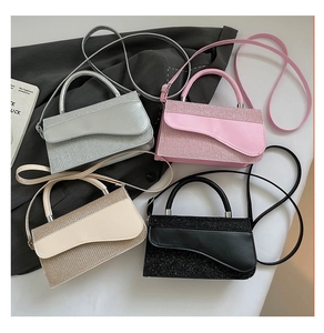 Detail view of four glittery crossbody bags in silver, pink, beige and black colors