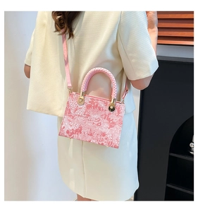 Detail of pink floral print handbag with woven handle and elegant classic pattern