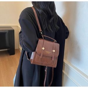Detail of vintage brown leather backpack with magnetic flap and gold button decorations