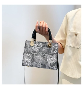 Detail of vintage French square bag with woven handle and jacquard fabric texture