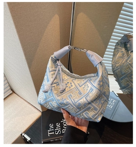 Détail du sac hobo en jacquard bleu clair avec motifs orientaux et poignée à perles