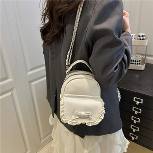 Mini-Rucksack-Umhängetasche aus PU-Leder mit Spitze und Schleife auf grauem Blazer
