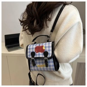 Détail du mini sac à dos à carreaux bleus et blancs avec motif pomme et lanières