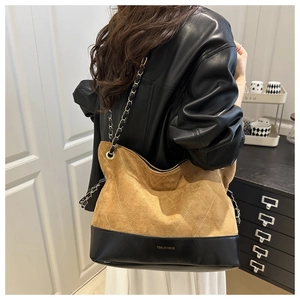 Detail of vintage quilted tote with brown suede, black leather and gold chain strap