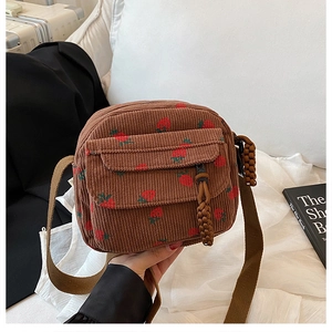 Close-up of brown corduroy crossbody bag featuring cute strawberry embroidery and flap pocket