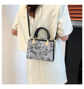 Detail of Toile de Jouy print tote bag with woven handles and gold hardware accents