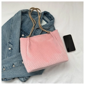Close-up of pink tote bag showing textured weave pattern and slim leather straps
