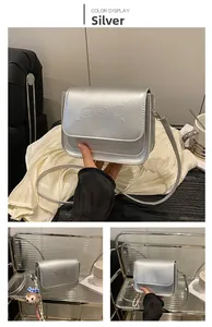 Détail d'un sac carré argenté avec oursons en relief et finition métallique chic