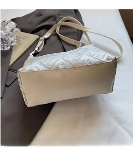 Vue détaillée d'un sac jacquard beige avec broderies florales sur une veste de costume