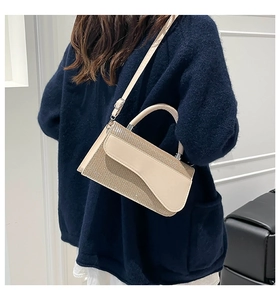 Détail du sac à main contrasté avec texture scintillante et rabat en cuir lisse élégant