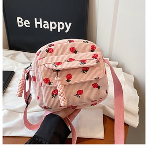 Close-up of pink corduroy crossbody bag with strawberry print and adjustable strap