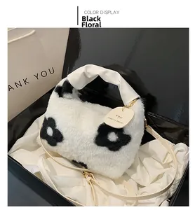 Détail du sac à main en peluche blanc avec fleurs noires et bandoulière amovible