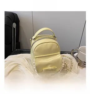 Close-up of pale yellow mini backpack with bow decoration and delicate lace trim details