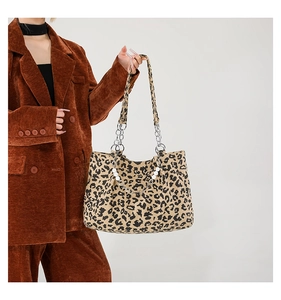 Detail of leopard print tote bag with stylish pearl and metal chain shoulder strap