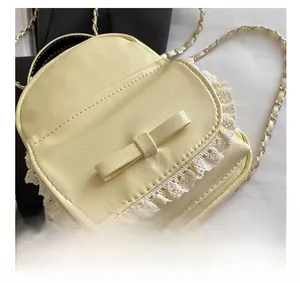 Close-up of yellow lychee leather mini backpack with lace trim and bow detail