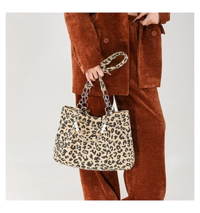 Detail of leopard print corduroy tote bag featuring pearl and silver chain accents