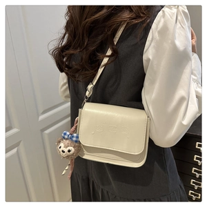 Détail du petit sac bandoulière crème avec oursons gaufrés et charm en peluche