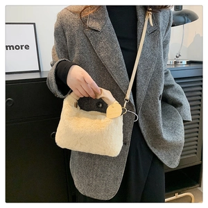 Détail d'un sac à main en peluche crème avec poignée en cuir et bandoulière marron