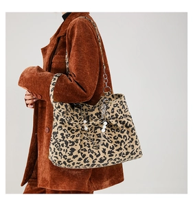 Close-up of leopard print tote bag with silver chain and pearl decorative charms