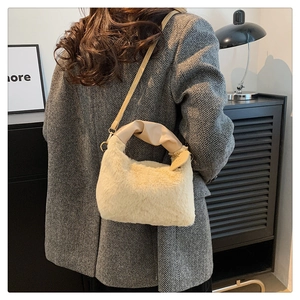 Détail du sac en peluche crème avec pendentif coeur et poignée en similicuir