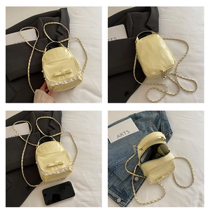 Detail view of light yellow mini backpack with lace bow and metal chain strap features