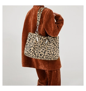Detail of leopard print tote bag featuring metallic chain and pearl accents on the shoulder