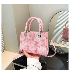 Close-up of pink jacquard handbag featuring floral patterns and woven leather handles