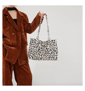 Detail of leopard print tote bag with stylish pearl and metal chain handle decoration