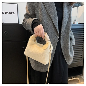 Détail du sac à main en fausse fourrure pelucheuse avec anses beige et finitions dorées