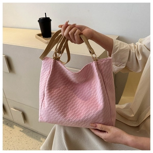 Detailed close-up of pink woven texture tote bag with beige handles and metal rings