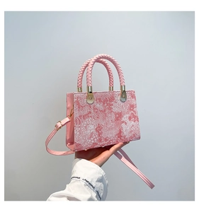 Macro detail of the pink marble textured finish and woven handle on a crossbody bag
