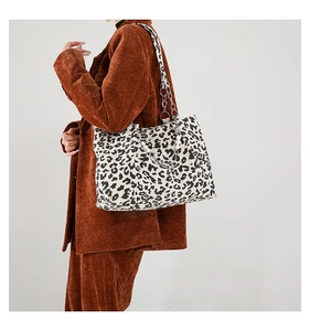 Close-up of leopard print tote bag with elegant pearl and metal chain shoulder straps