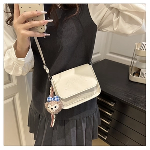 Détail du sac à bandoulière en PU blanc avec motif d'ours et charm en peluche assorti