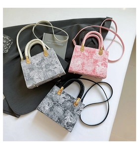 Detailed view of mini tote bags featuring vintage floral patterns in grey, pink, and black