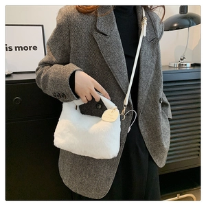 Détail du sac à main en fausse fourrure blanche avec breloque cœur dorée élégante
