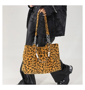 Detail of leopard print tote bag featuring silver chain and white pearl strand handle