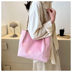Detail of light pink woven tote bag with suede texture and slim straps in minimalist interior